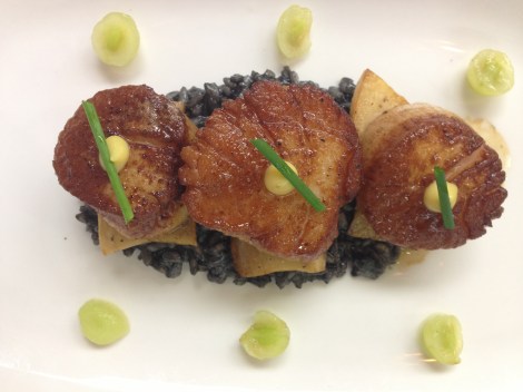 Scallops on a bed of squid ink risotto